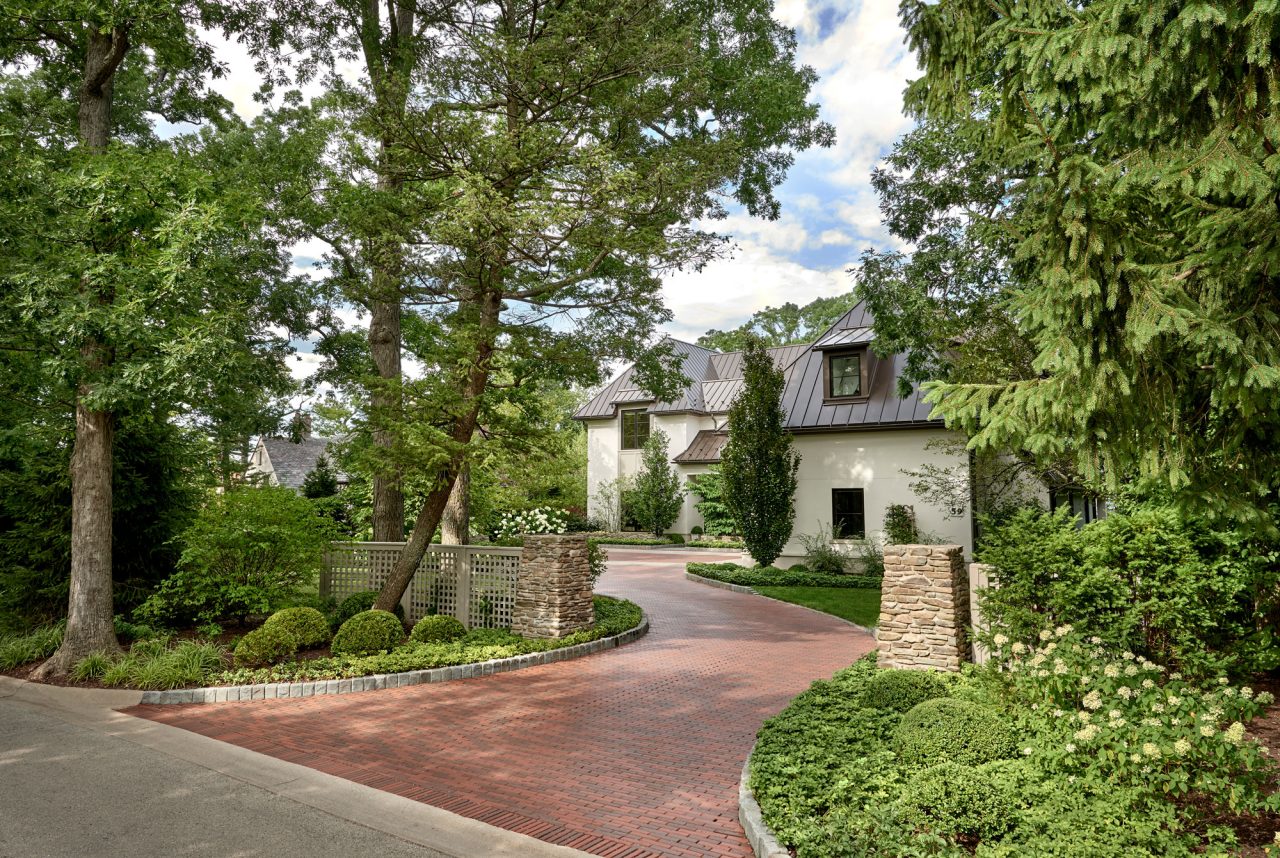 Winding brick driveway surrounded by greenery