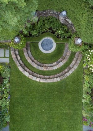 An award winning European influenced symmetrical garden with stone walls and a fountain focal point.