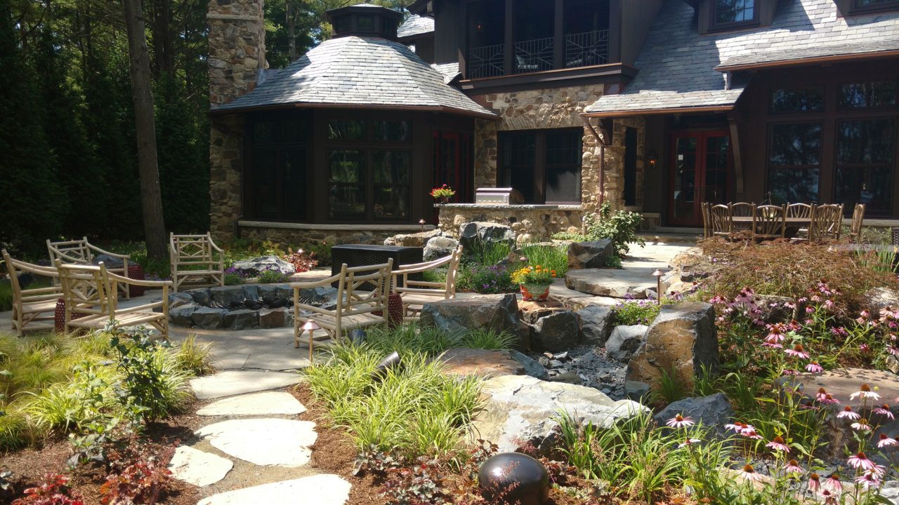 Stone deck with gun metal fire pit and embedded rock path