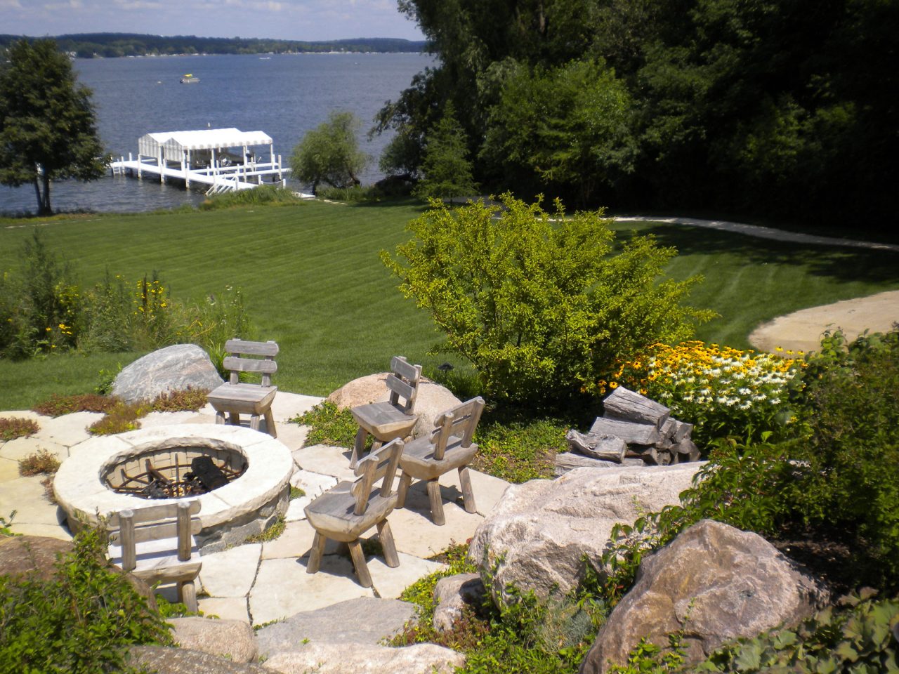 Raised fire pit with granite cobble wall and rockfaced flagstone coping overlooking Lake Geneva