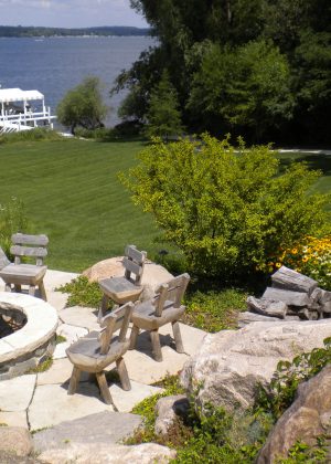 Raised fire pit with granite cobble wall and rockfaced flagstone coping overlooking Lake Geneva