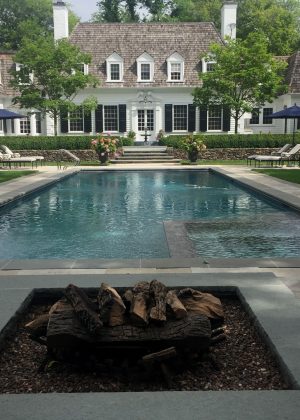 Flagstone pool deck with bluestone banding and firepit with bluestone coping
