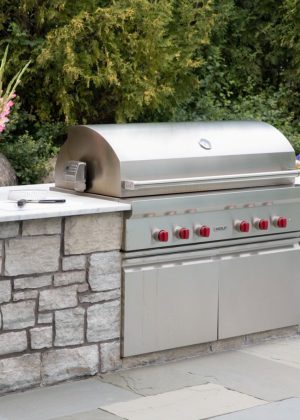 Elegant outdoor kitchen grill setup with custom hardscape counter