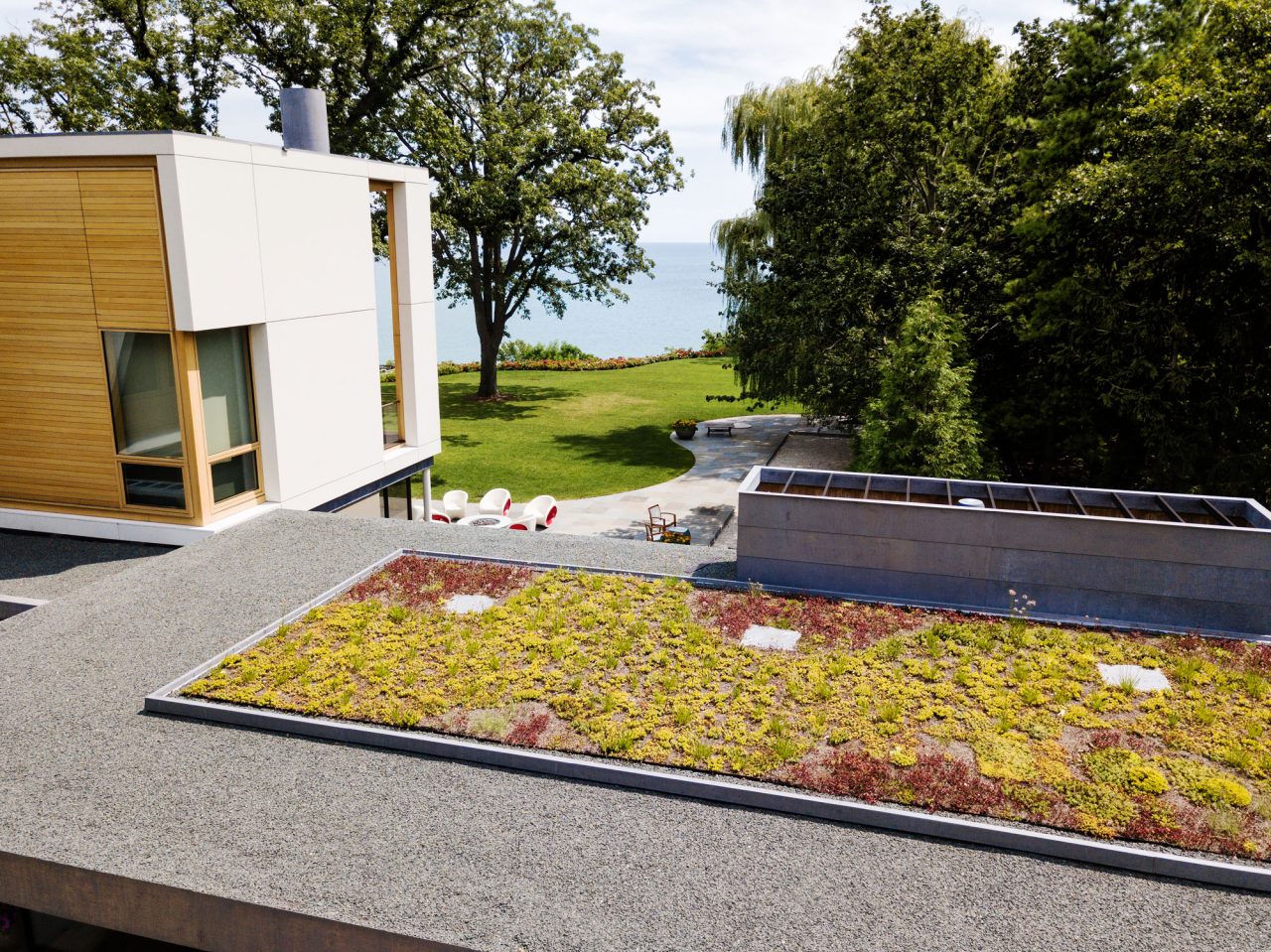 Sedum garden on garage roof overlooking the modern house, lawn, and Lake Michigan in the background.