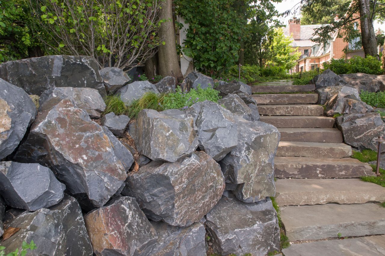 Fieldstone slab steps with boulder wall and boulder outcroppings