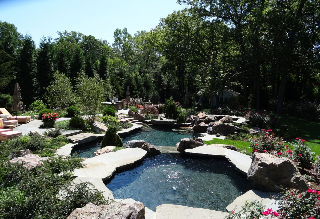 Naturalized dual pool with waterfall and bluestone terrace