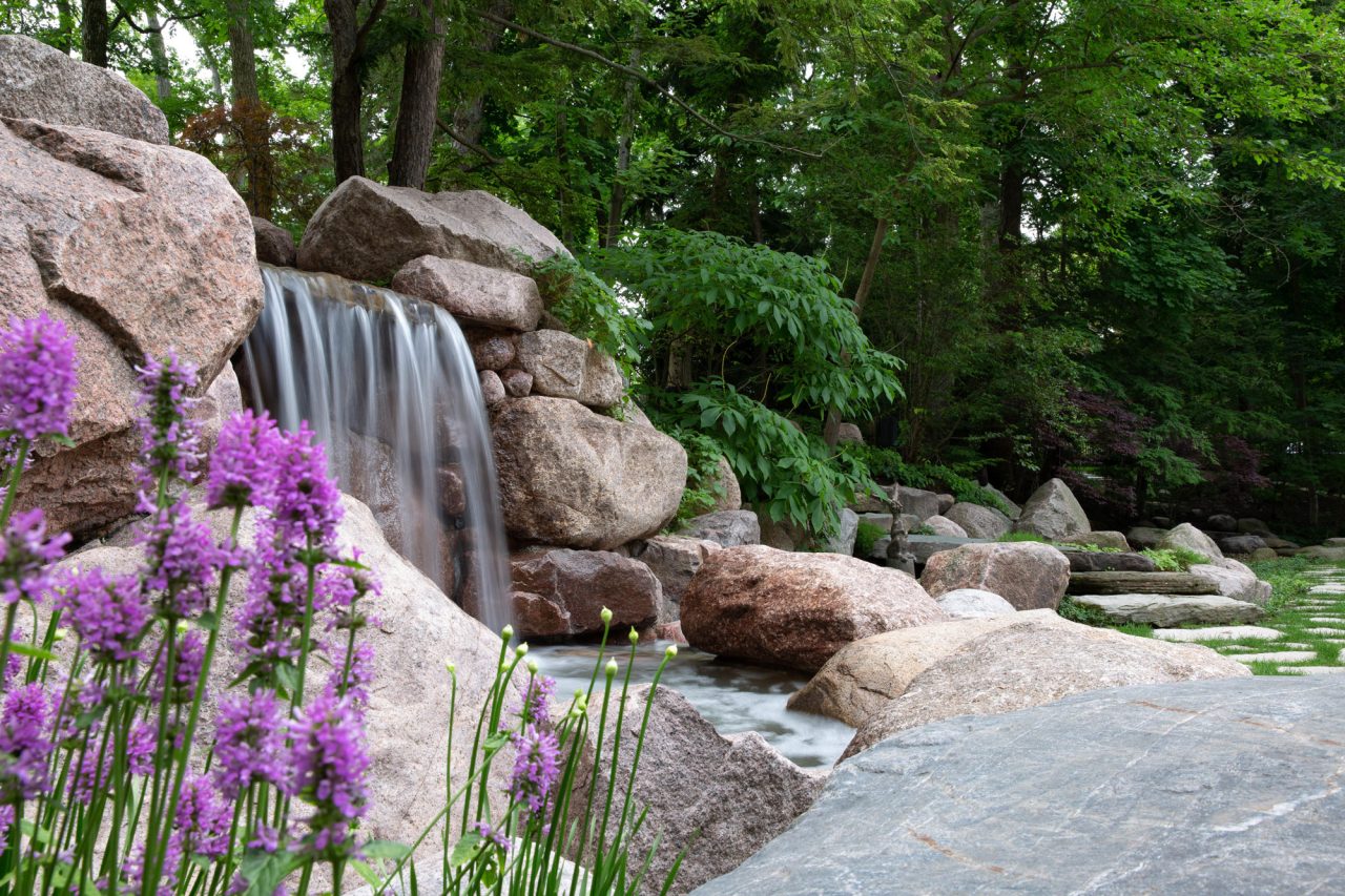 Waterfall surrounded by natural landscape featuring perennials