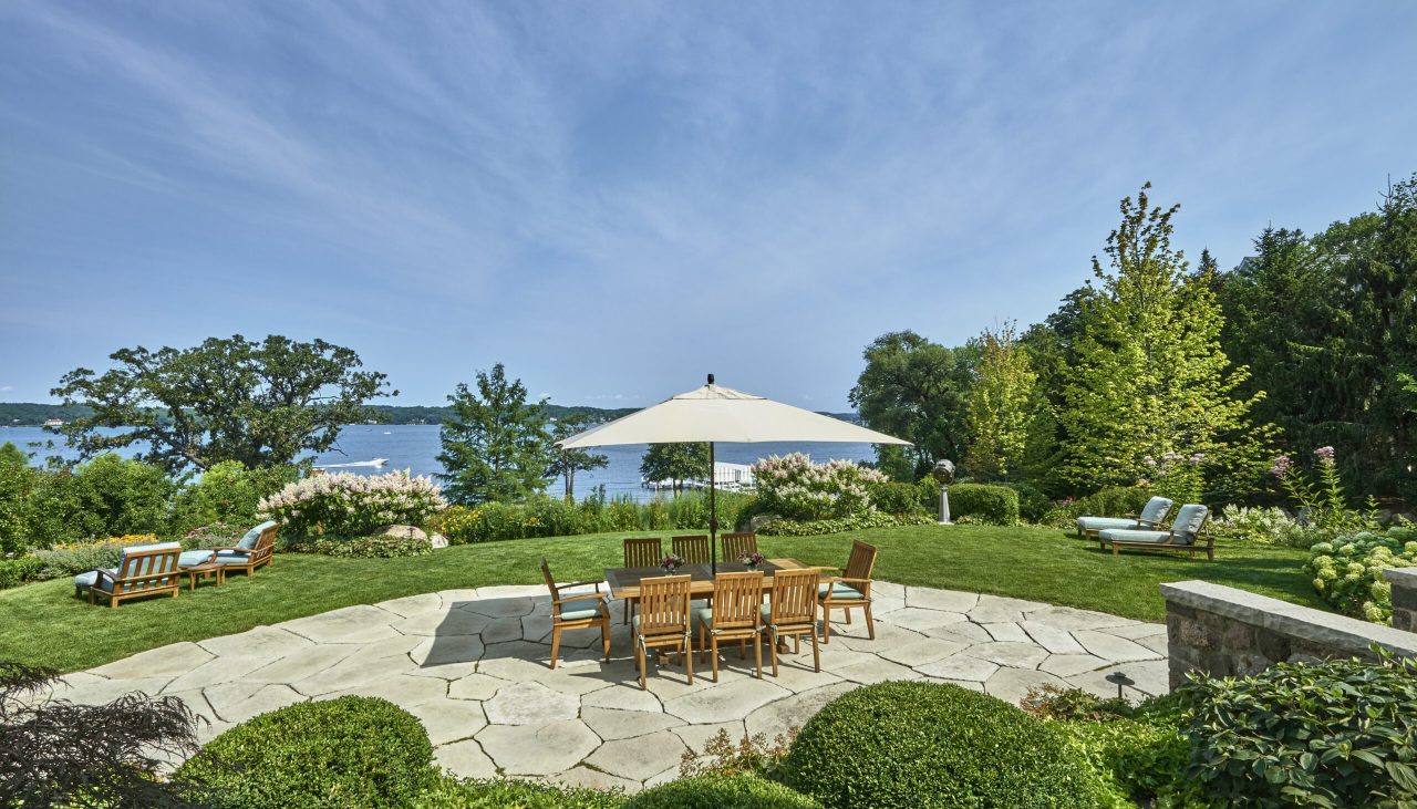 Stone deck with custom furniture overlooking lake