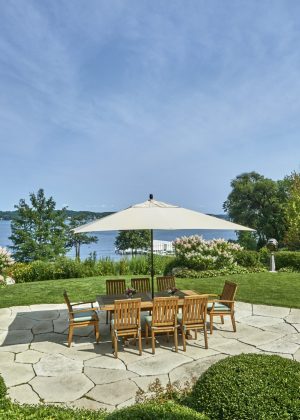 Stone deck with custom furniture overlooking lake