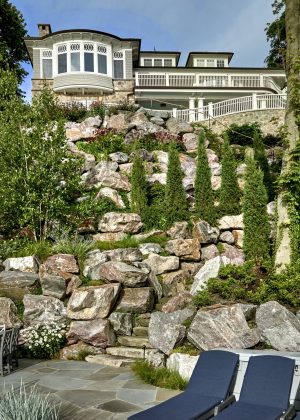 Bluff with boulder inlay, flagstone steps, and deck