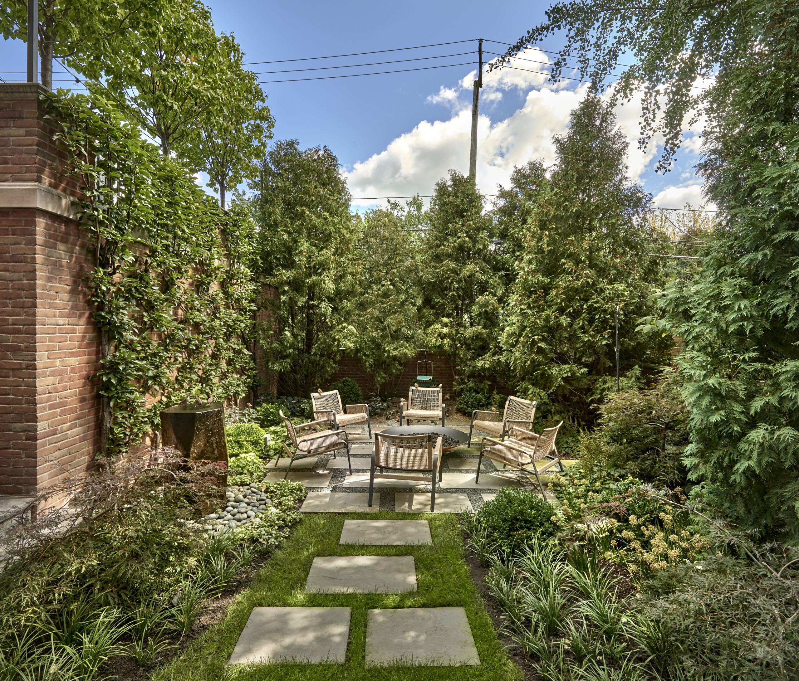 Urban garden with stepper path, custom fountain, perennial and lattice border